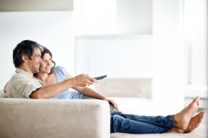 Relaxed mature couple watching tv at home